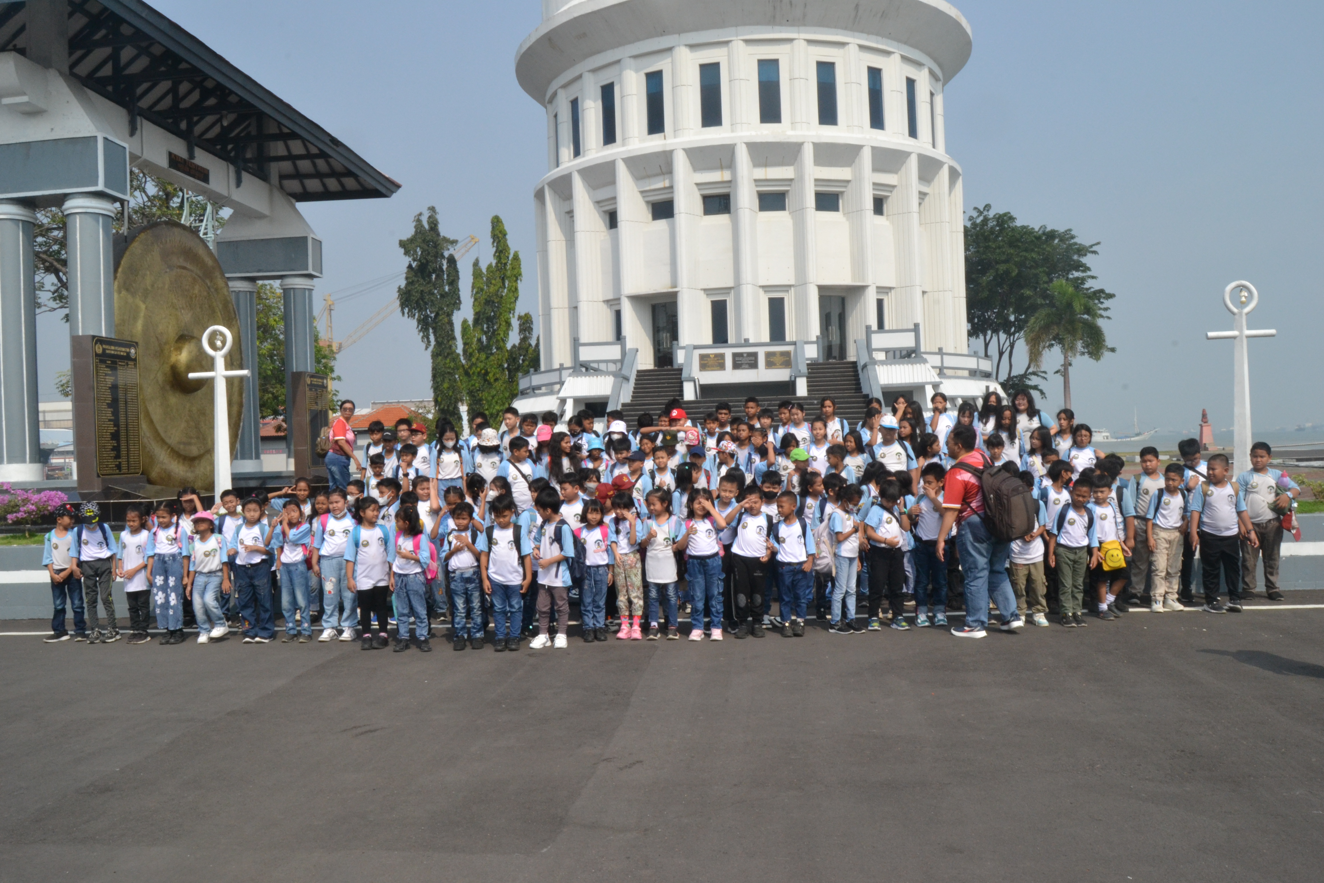 Rombongan murid dan pendamping berfoto bersama di depan gedung